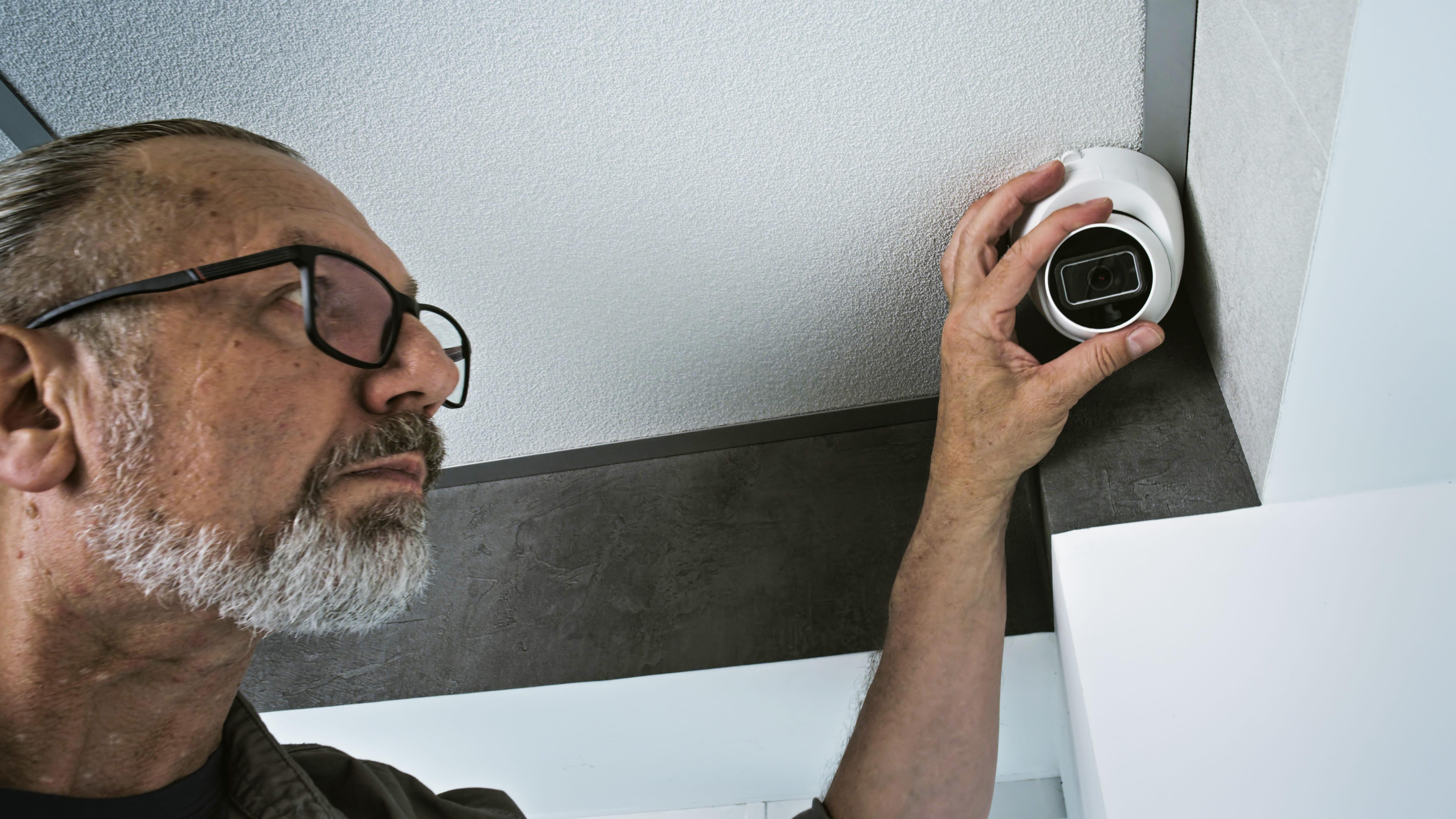 Man carrying out Home CCTV Installation by adjusting a security camera inside a residential property.
